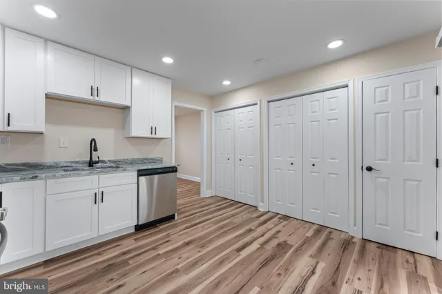a kitchen with granite countertop white cabinets and stainless steel appliances