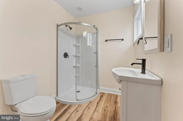 a bathroom with a sink a toilet and shower