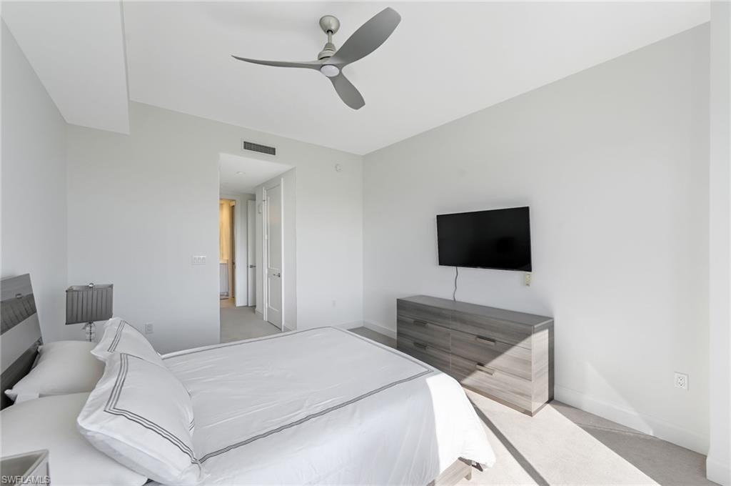 1111 Central, Unit 417A Naples, FL 34104 - Photo 13 of 25 a bedroom with a bed and a flat screen tv