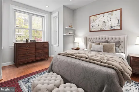 a bedroom with a bed and a lamp on the dresser