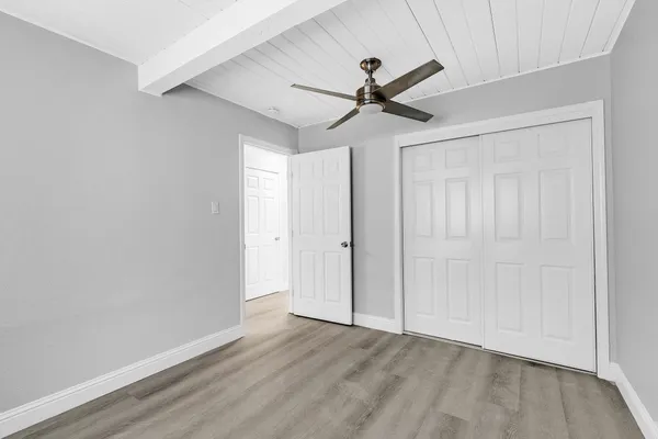 a view of a big room with wooden floor closet and windows
