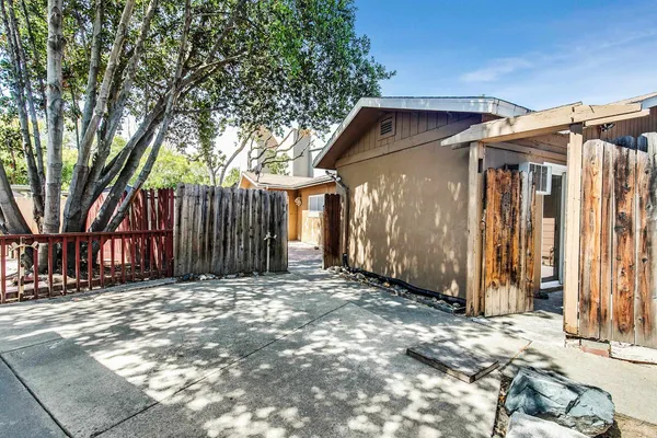 a view of a house with a small yard and wooden fence