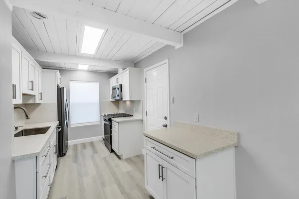 a kitchen with stainless steel appliances a refrigerator sink and stove