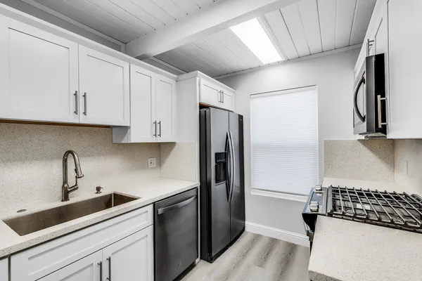 a kitchen with stainless steel appliances a refrigerator sink and cabinets