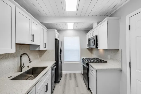 a kitchen with stainless steel appliances granite countertop a sink stove and refrigerator