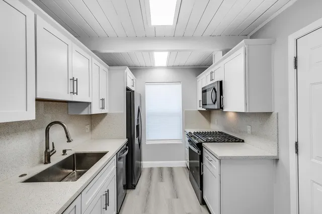 a kitchen with stainless steel appliances granite countertop a sink stove and refrigerator