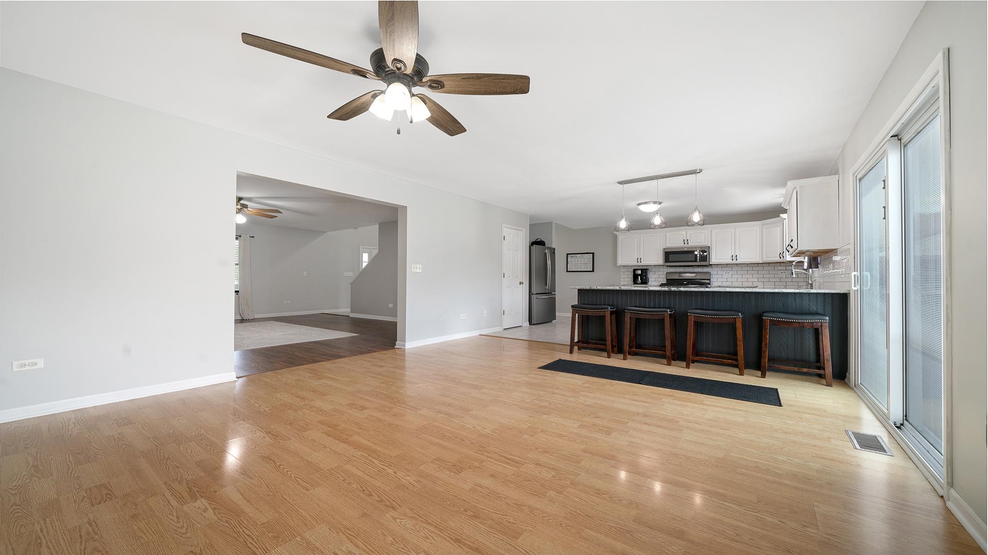 7903 Graf Road Harvard, IL 60033 - Photo 11 of 52 a view of a livingroom with a ceiling fan and wooden floor