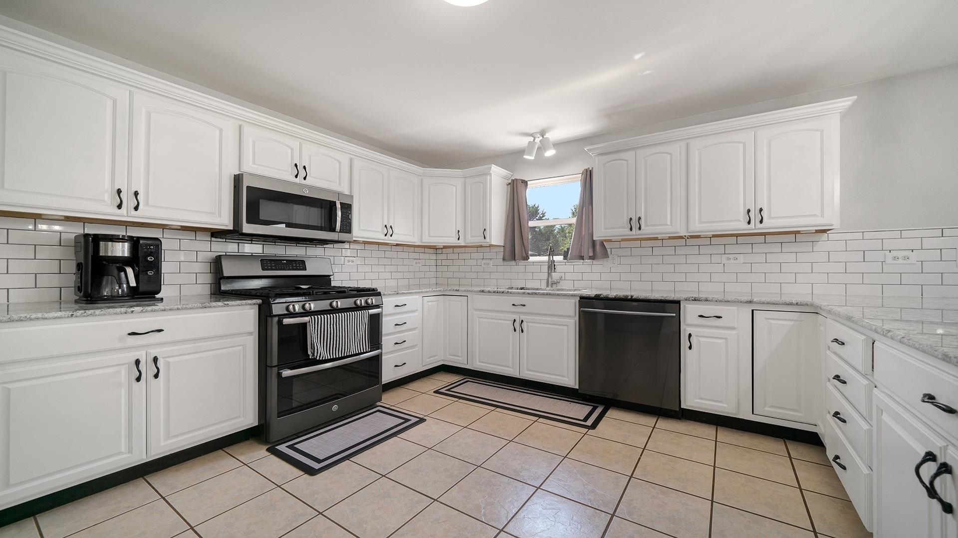 7903 Graf Road Harvard, IL 60033 - Photo 14 of 52 a kitchen with cabinets stainless steel appliances and a sink
