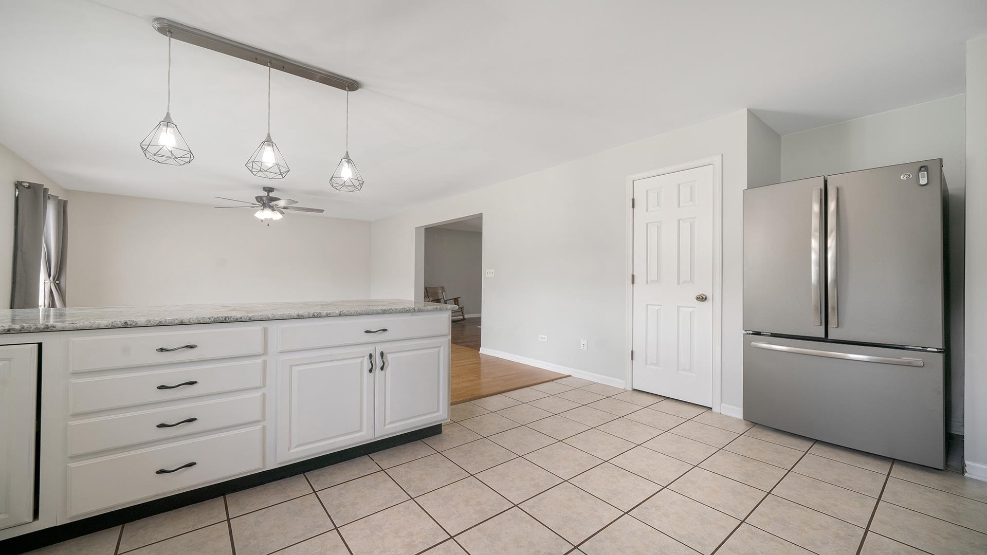 7903 Graf Road Harvard, IL 60033 - Photo 16 of 52 a kitchen with white cabinets and refrigerator
