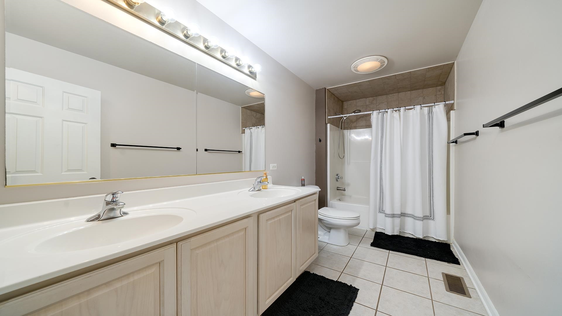 7903 Graf Road Harvard, IL 60033 - Photo 25 of 52 a bathroom with a double vanity sink toilet and a tub