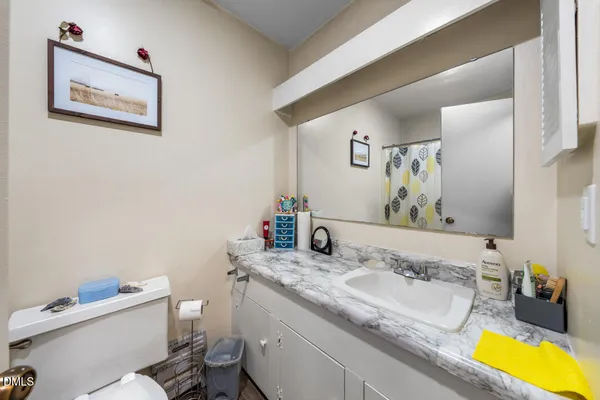 a bathroom with a granite countertop sink and a mirror