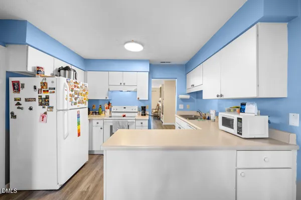 a kitchen with refrigerator and cabinets