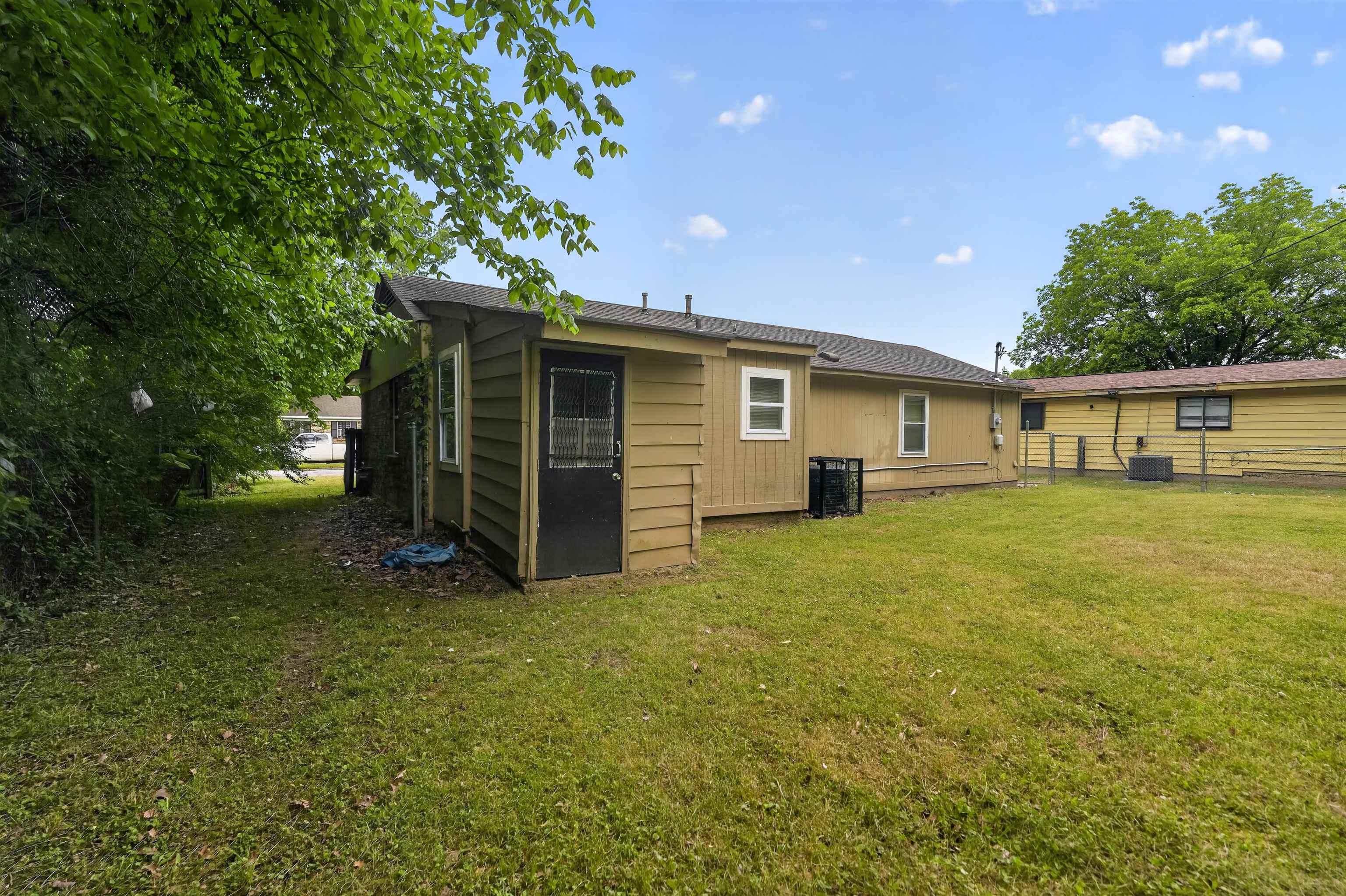 3608 Cane Ridge Drive Memphis, TN 38109 - Photo 5 of 31 Expansive backyard area featuring a manicured lawn, exterior siding, and mature perimeter trees