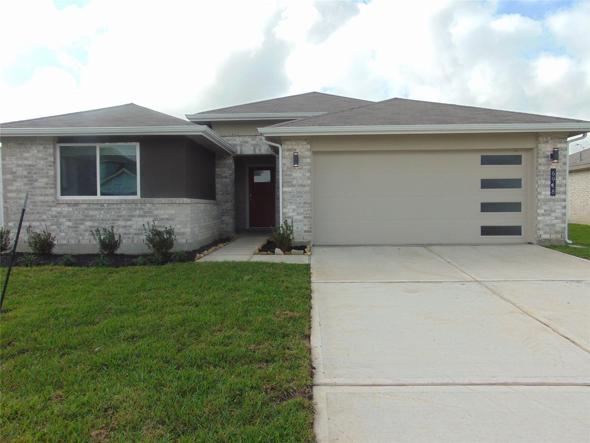 6918 Morales Way Richmond, TX 77469 - Photo 2 of 17 a front view of a house with a garden
