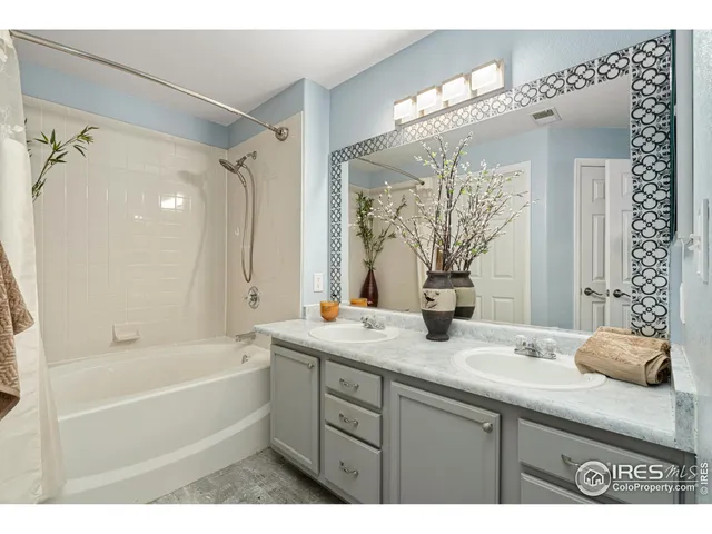 a bathroom with a granite countertop sink mirror and a bathtub