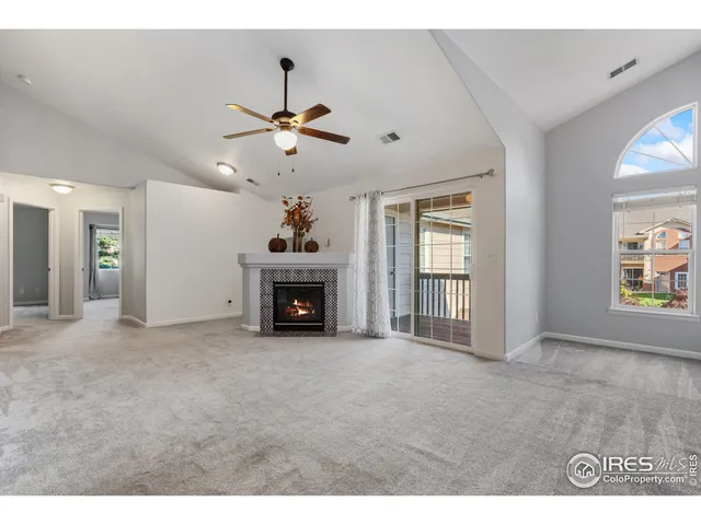 a view of an empty room with a fireplace and a window