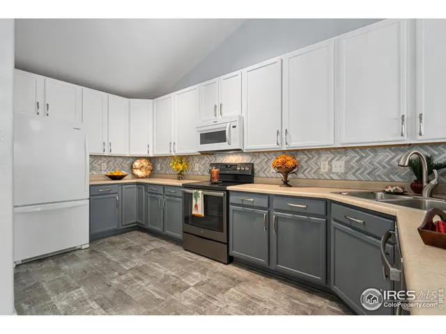 a kitchen with granite countertop a refrigerator sink and cabinets