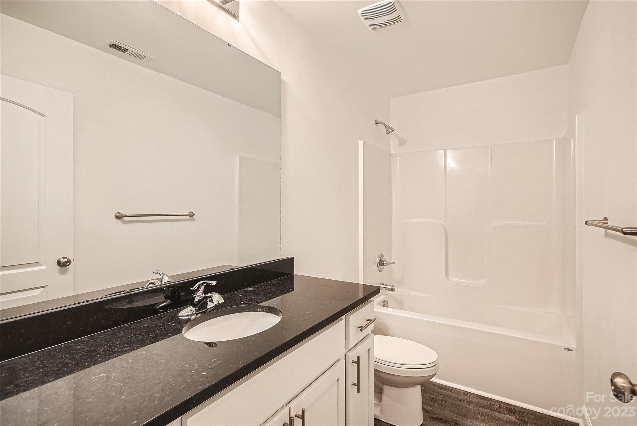 1526 Shepard Street Kannapolis, NC 28083 - Photo 8 of 10 a bathroom with a granite countertop sink toilet a mirror and shower