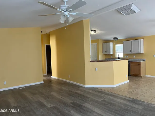 a view of a kitchen with a sink a ceiling fan and wooden floor