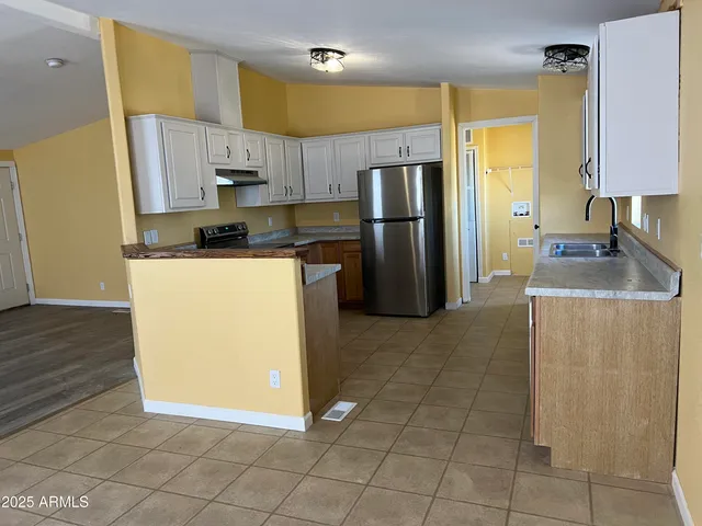 a kitchen with stainless steel appliances granite countertop a refrigerator a stove and a sink