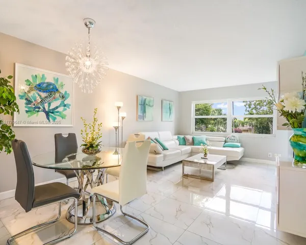 a living room with furniture a dining table and a chandelier