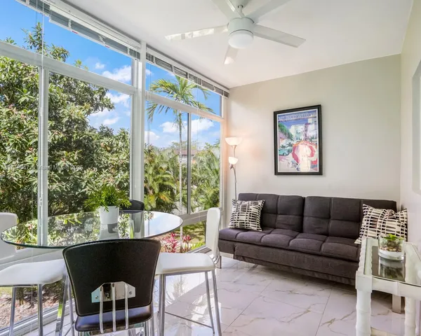 a living room with furniture potted plant and a large window
