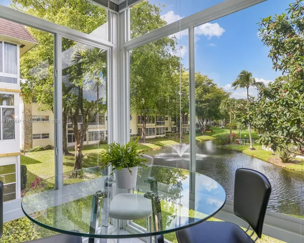 a dining room with glass top table and chairs