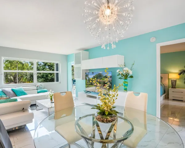 a living room with patio furniture and a chandelier