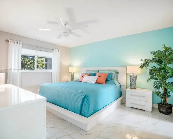 a bedroom with a large bed and a potted plant