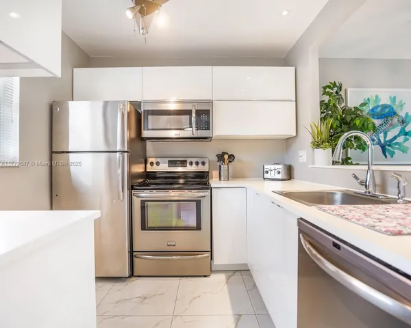 a kitchen with a sink a refrigerator and a stove top oven