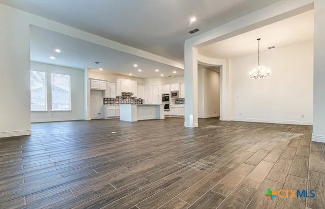 a kitchen with a stove a refrigerator and wooden floor
