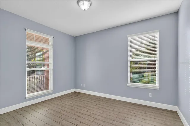 a view of a room with wooden floor and windows