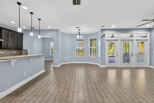 a kitchen with stainless steel appliances granite countertop a sink a stove and a wooden floors