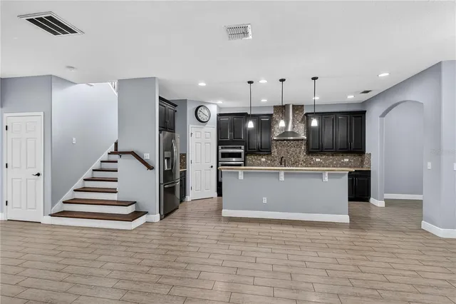 an empty room with wooden floor and ceiling fan
