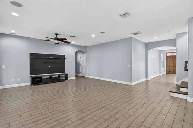 a view of an empty room with window and wooden floor