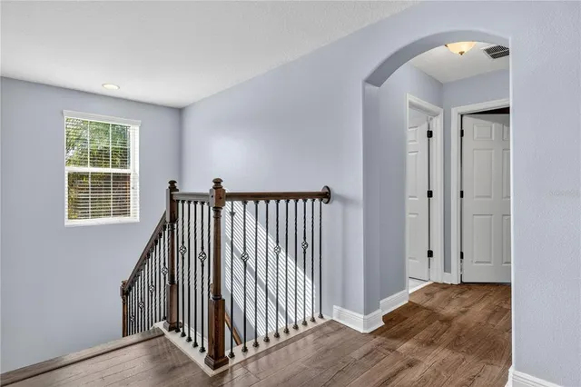 a view of a hallway with wooden floor and entryway