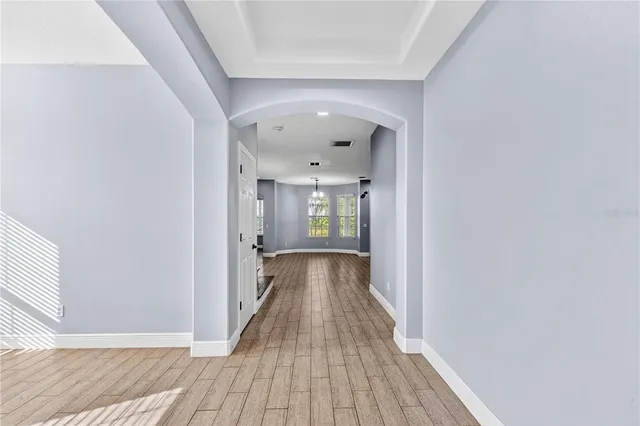 a view of an empty room with wooden floor and windows