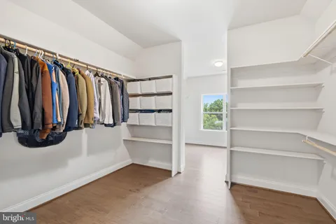 a view of walk in closet with clothes and shoes