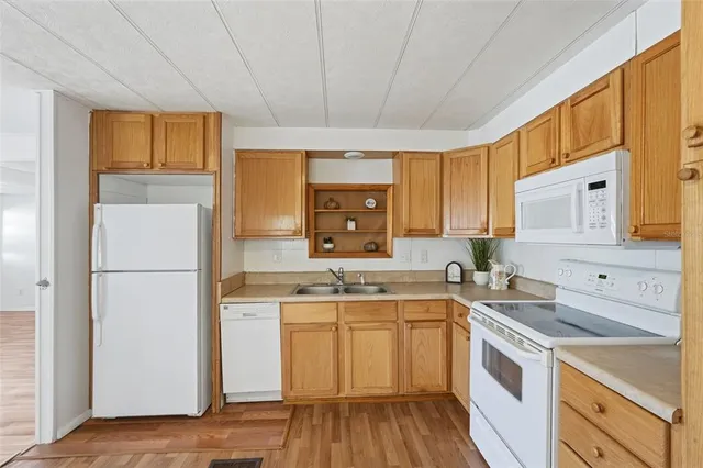 a kitchen with a sink a refrigerator a window and cabinets