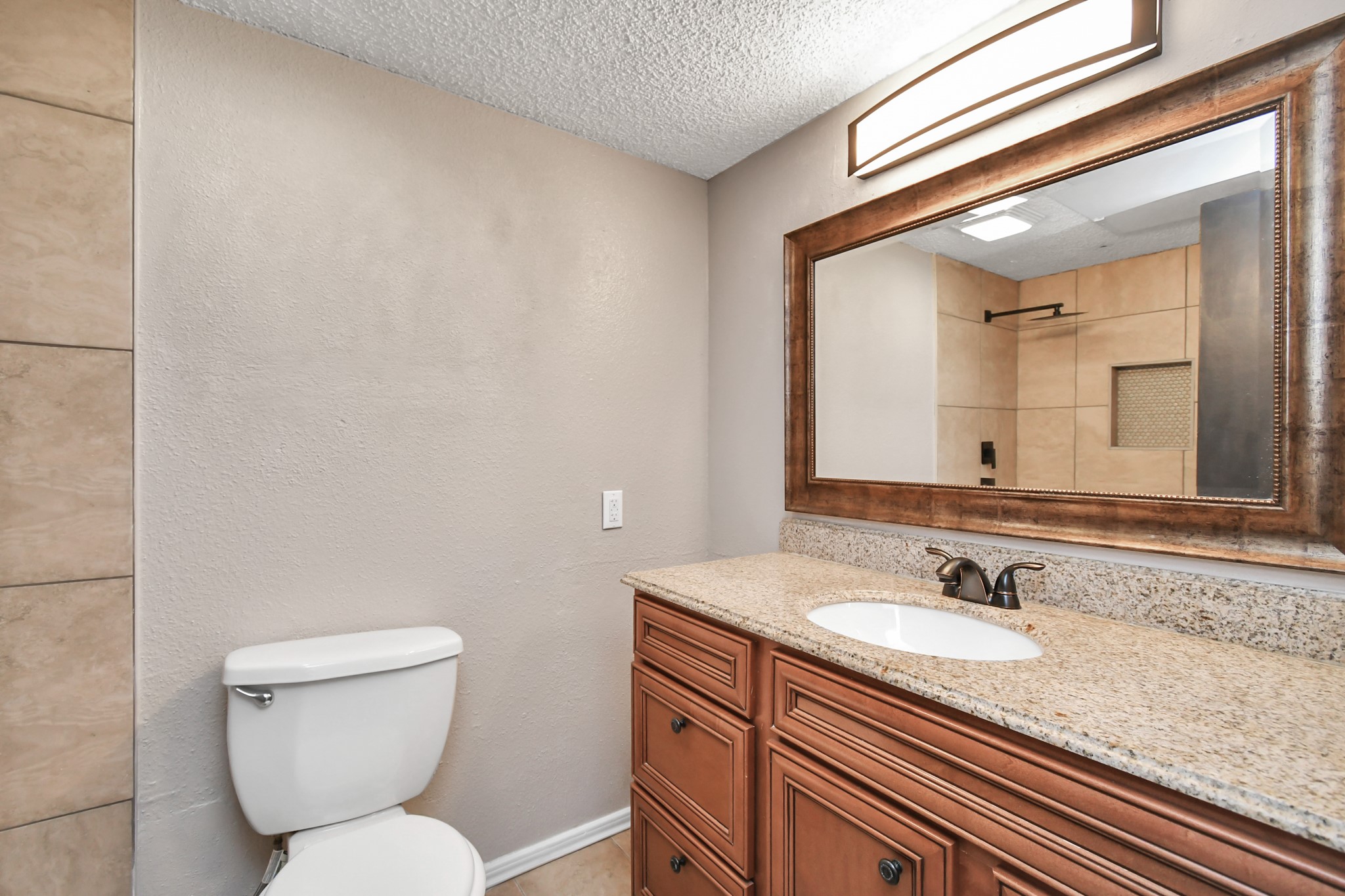 1505 Ward Road, Unit 182 Baytown, TX 77520 - Photo 16 of 20 a bathroom with a granite countertop toilet sink and mirror
