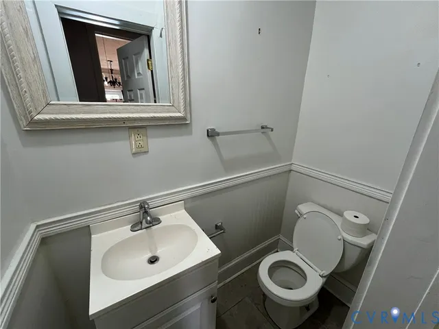 a bathroom with a toilet sink vanity and mirror