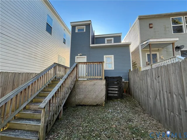 a view of a house with backyard and wooden fence