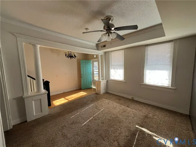 a view of empty room with window and ceiling fan
