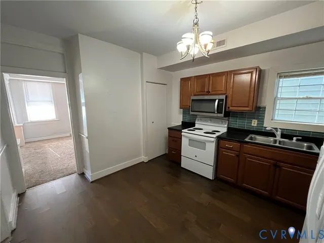 a kitchen with stainless steel appliances granite countertop a stove a sink and a microwave