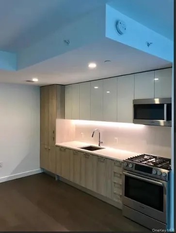 a modern kitchen with stainless steel appliances granite countertop a sink and a stove