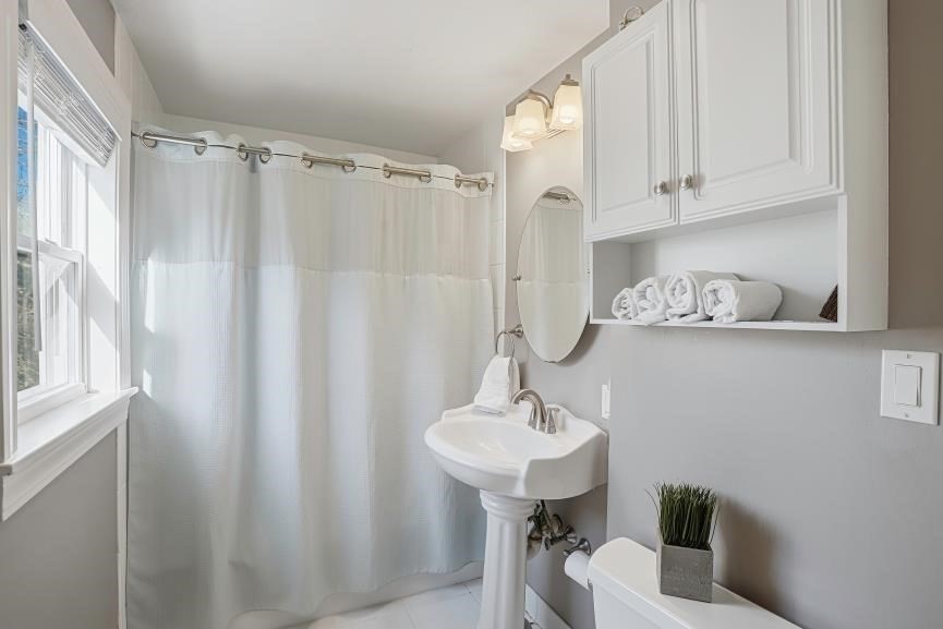 49 Grove Street Upton, MA 01568 - Photo 22 of 39 a bathroom with a sink a mirror and a shower curtain