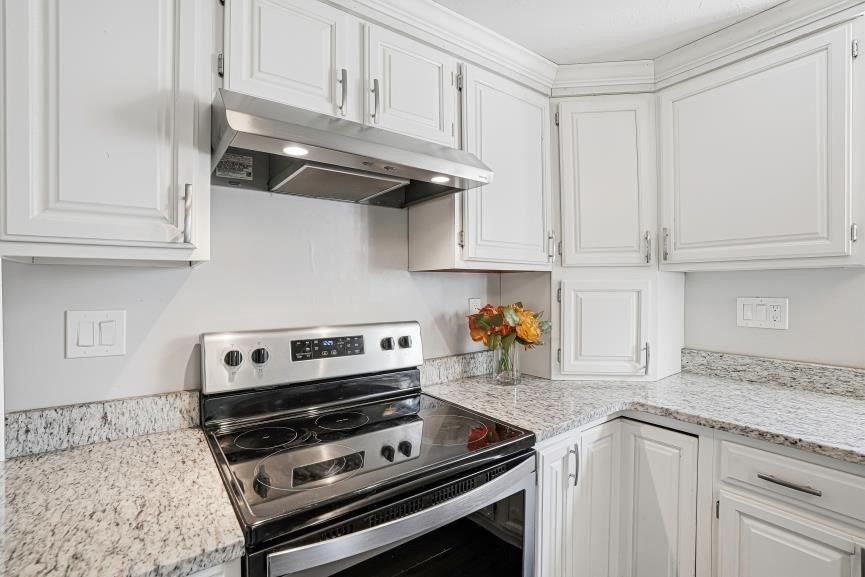 49 Grove Street Upton, MA 01568 - Photo 7 of 39 a kitchen with granite countertop a stove a microwave and cabinets
