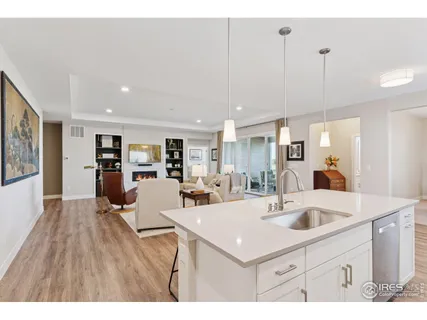 a view of kitchen island a sink wooden floor and living room view