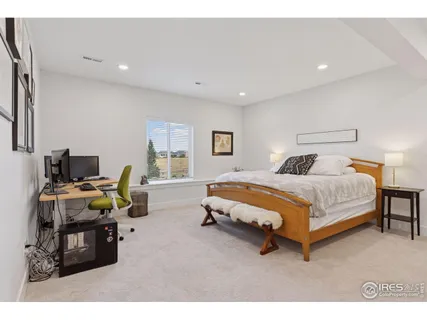 a bedroom with a bed a couch and a chandelier