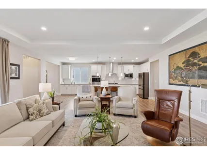a living room with furniture white walls and kitchen view